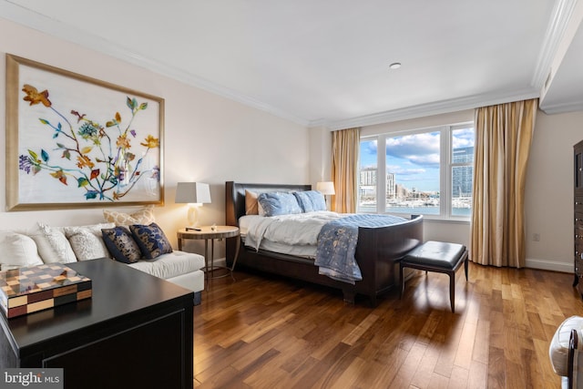 bedroom with baseboards, wood finished floors, and crown molding