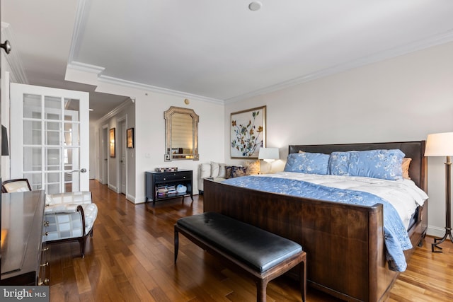 bedroom with wood-type flooring, ornamental molding, and baseboards