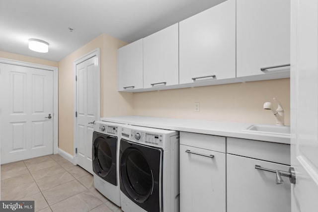 washroom featuring light tile patterned floors, cabinet space, a sink, and separate washer and dryer