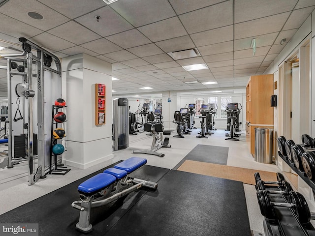 gym with baseboards and a drop ceiling