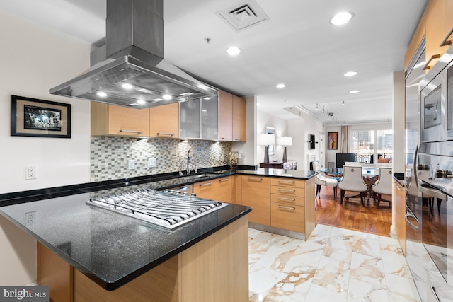 kitchen featuring marble finish floor, island exhaust hood, visible vents, stainless steel gas stovetop, and a peninsula