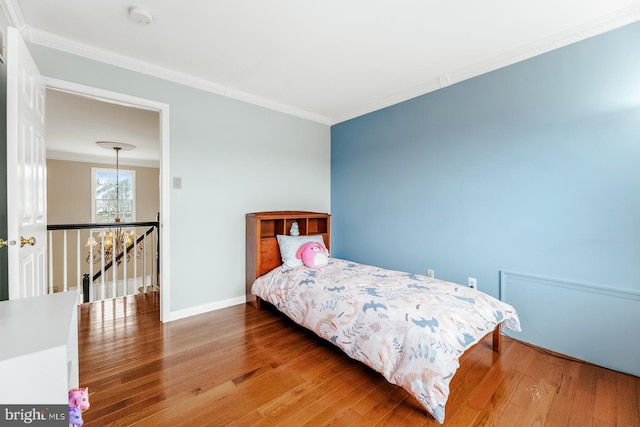 bedroom with hardwood / wood-style floors, baseboards, and ornamental molding