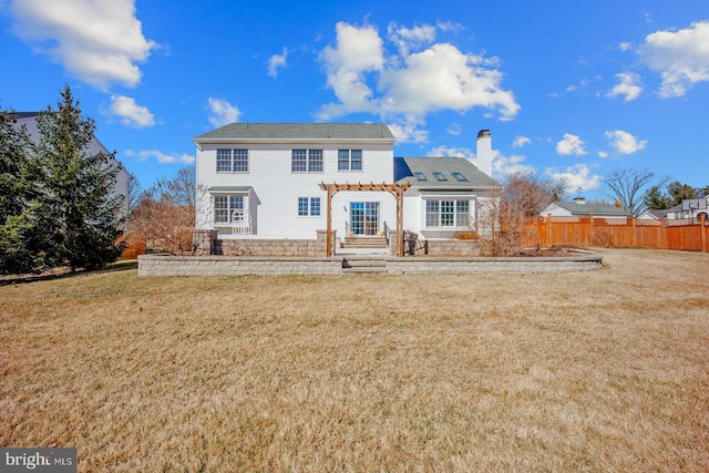 rear view of property featuring a chimney, a lawn, a pergola, and fence