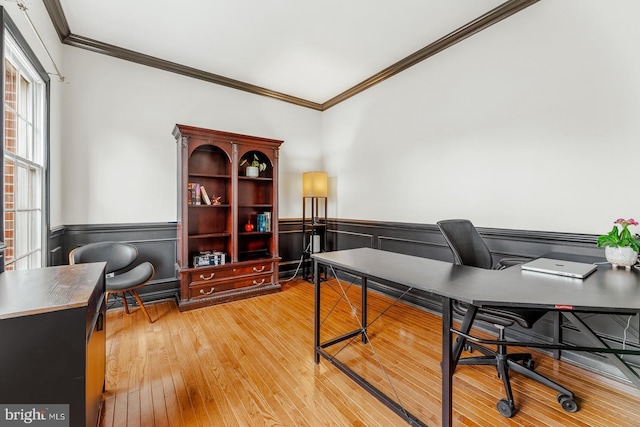 office space with wainscoting, crown molding, and light wood-style floors