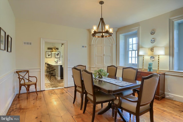 dining room featuring visible vents, a notable chandelier, and light wood finished floors