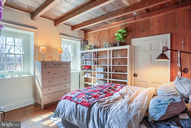 bedroom with wood walls, wood ceiling, baseboards, beamed ceiling, and wood-type flooring