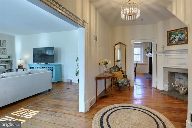 interior space with light wood-style flooring, visible vents, a chandelier, and baseboards