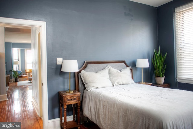 bedroom with baseboards and wood finished floors