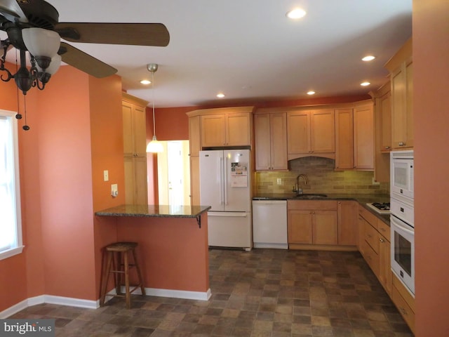 kitchen featuring pendant lighting, decorative backsplash, a sink, white appliances, and a peninsula