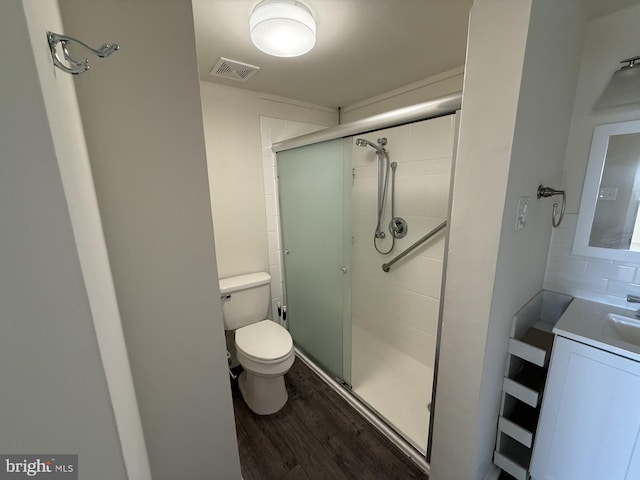 full bathroom with toilet, wood finished floors, vanity, visible vents, and a shower stall