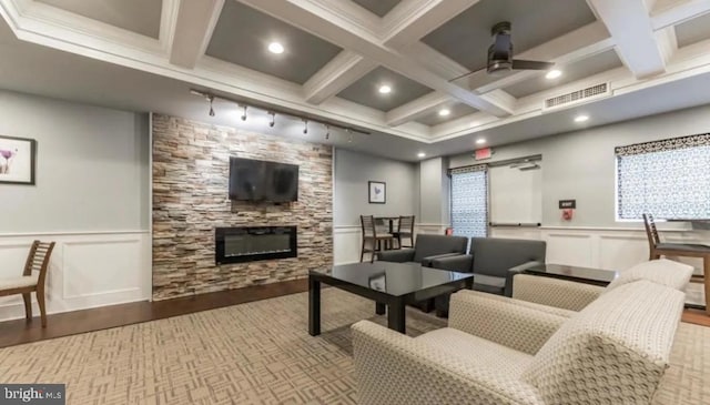 living room featuring beam ceiling, visible vents, and a fireplace