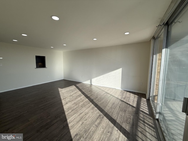 empty room featuring baseboards, wood finished floors, and recessed lighting