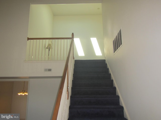 staircase with baseboards and visible vents