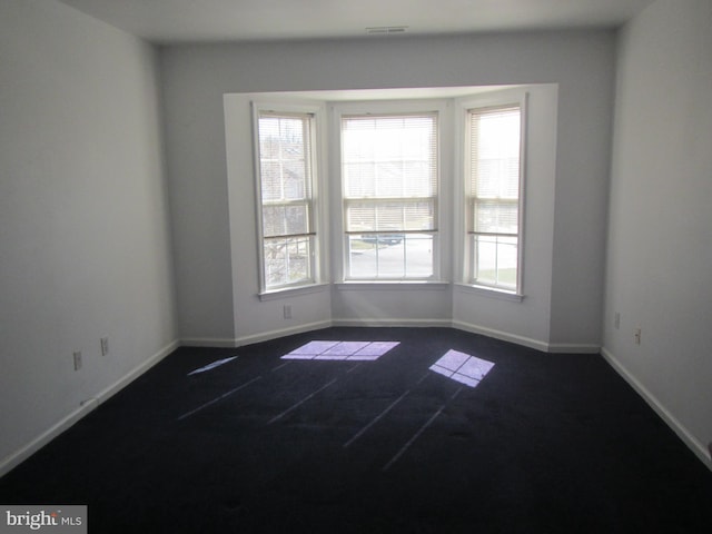 unfurnished room featuring visible vents and baseboards