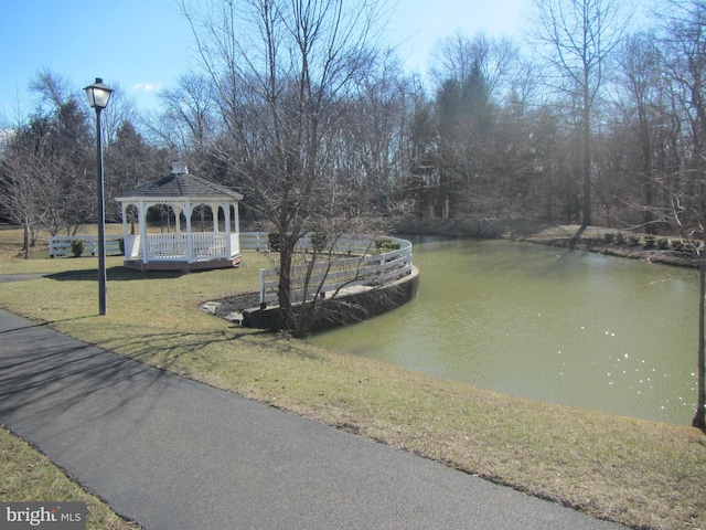 view of property's community with a gazebo, a yard, and a water view