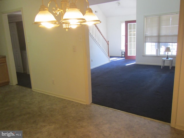 carpeted spare room featuring stairs, baseboards, and an inviting chandelier