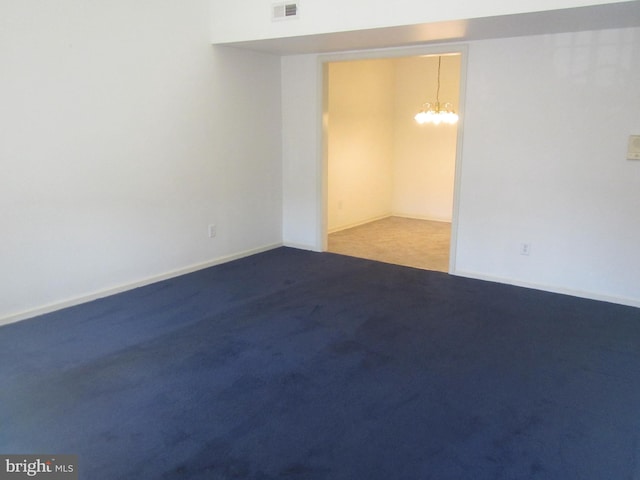 unfurnished room featuring carpet floors, visible vents, and baseboards