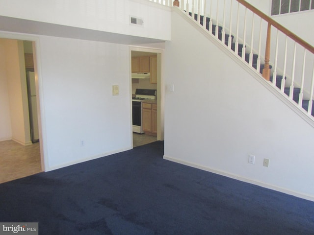 interior space featuring carpet floors, stairway, and visible vents