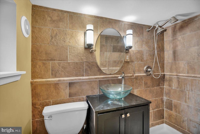 bathroom featuring tiled shower, vanity, and toilet