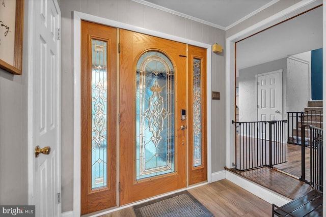 entrance foyer with ornamental molding and wood finished floors