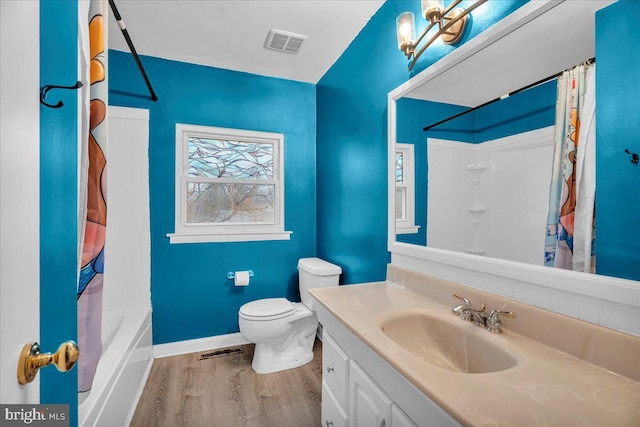 bathroom featuring baseboards, visible vents, toilet, wood finished floors, and vanity