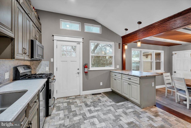 kitchen featuring baseboards, appliances with stainless steel finishes, light stone countertops, tasteful backsplash, and decorative light fixtures