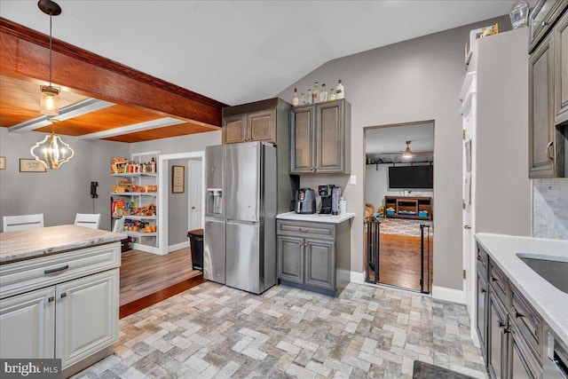 kitchen featuring baseboards, stainless steel refrigerator with ice dispenser, a notable chandelier, and gray cabinetry