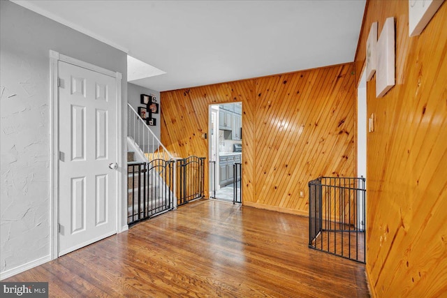 interior space with wood walls, stairway, and wood finished floors