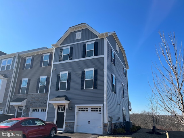 153 Glory Maple Ln, Downingtown, PA 19335 - view of property featuring stone siding, cooling unit, board and batten siding, and an attached garage