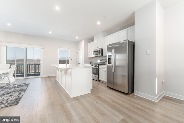 153 Glory Maple Ln, Downingtown, PA 19335 - kitchen featuring light wood-style flooring, a kitchen island with sink, a sink, white cabinets, and appliances with stainless steel finishes
