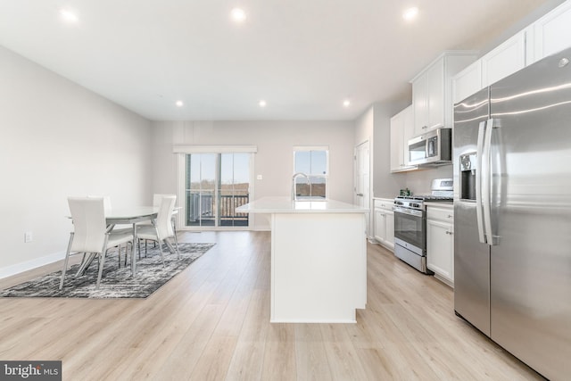 153 Glory Maple Ln, Downingtown, PA 19335 - kitchen featuring an island with sink, light countertops, light wood-type flooring, appliances with stainless steel finishes, and a sink