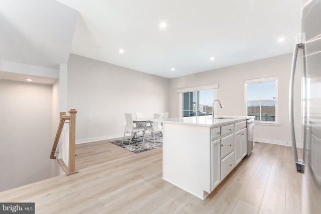 153 Glory Maple Ln, Downingtown, PA 19335 - kitchen featuring light wood finished floors, a sink, a center island with sink, white cabinets, and stainless steel dishwasher