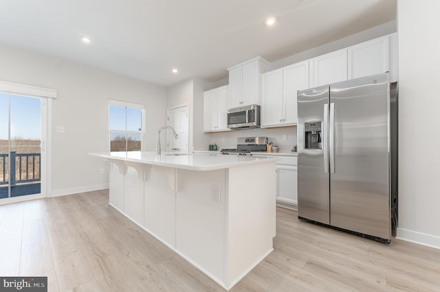 153 Glory Maple Ln, Downingtown, PA 19335 - kitchen featuring light wood-style flooring, an island with sink, a sink, light countertops, and appliances with stainless steel finishes