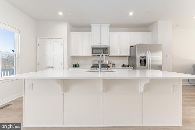 153 Glory Maple Ln, Downingtown, PA 19335 - kitchen featuring white cabinets, a kitchen island with sink, appliances with stainless steel finishes, and light wood-type flooring