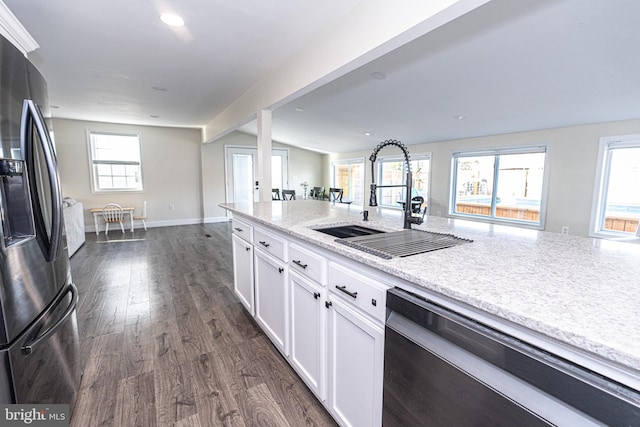 kitchen with dark wood-type flooring, dishwashing machine, stainless steel fridge, white cabinetry, and a sink