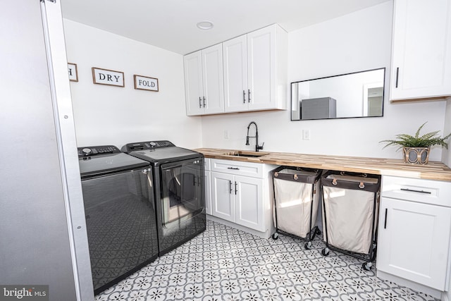 washroom with washer and clothes dryer, cabinet space, and a sink