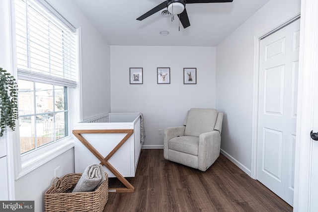 living area featuring ceiling fan, baseboards, and dark wood finished floors