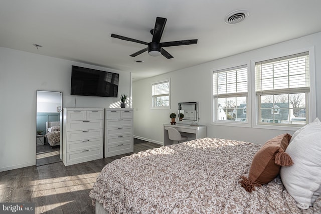 bedroom featuring a ceiling fan, visible vents, dark wood-style flooring, and baseboards