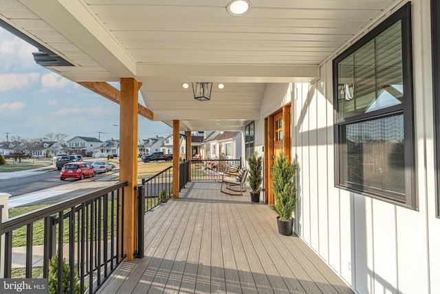 wooden terrace featuring a residential view and a porch