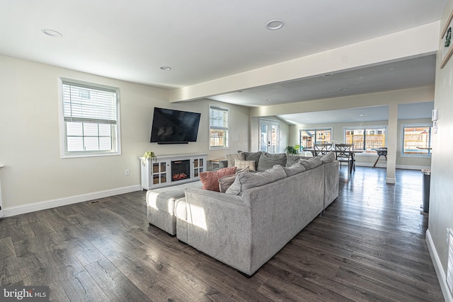 living room featuring dark wood finished floors, plenty of natural light, recessed lighting, and baseboards