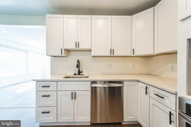 kitchen featuring light countertops, a sink, white cabinets, and appliances with stainless steel finishes