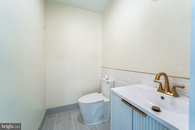 bathroom featuring toilet, tile patterned flooring, and vanity