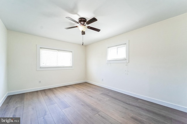 spare room featuring a ceiling fan, baseboards, and wood finished floors