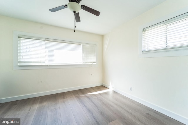 empty room with baseboards, ceiling fan, and wood finished floors
