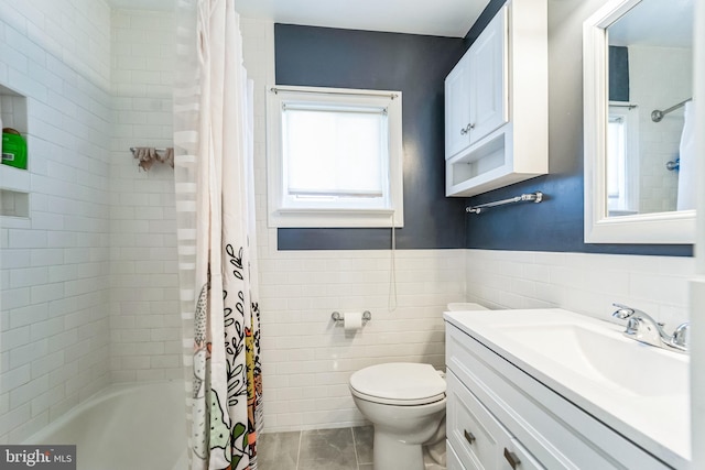 full bathroom with a wainscoted wall, tile walls, toilet, vanity, and shower / bath combination with curtain