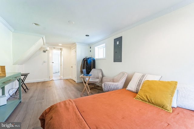 bedroom with wood finished floors, crown molding, baseboards, and electric panel