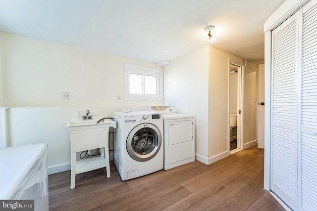 laundry room featuring baseboards, laundry area, washer and dryer, and light wood finished floors