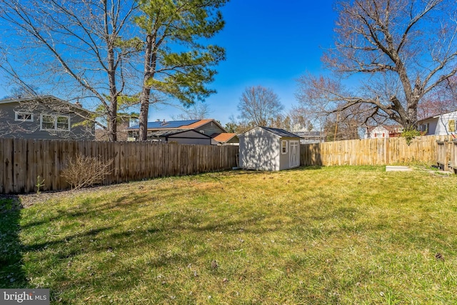 view of yard featuring a storage shed, an outdoor structure, and a fenced backyard