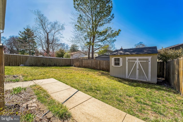 view of yard featuring an outdoor structure, a fenced backyard, and a storage shed