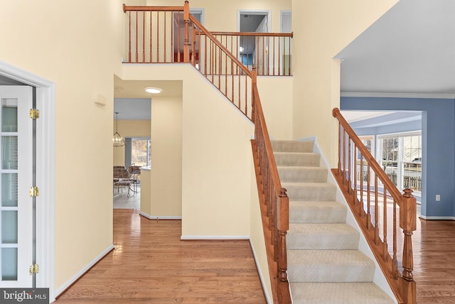 stairs featuring wood finished floors, a wealth of natural light, and baseboards